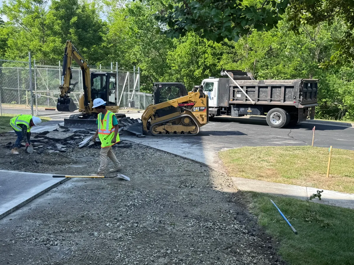 Excavator, skid steer, and crew removing broken pavement on a J. Coble demolition project