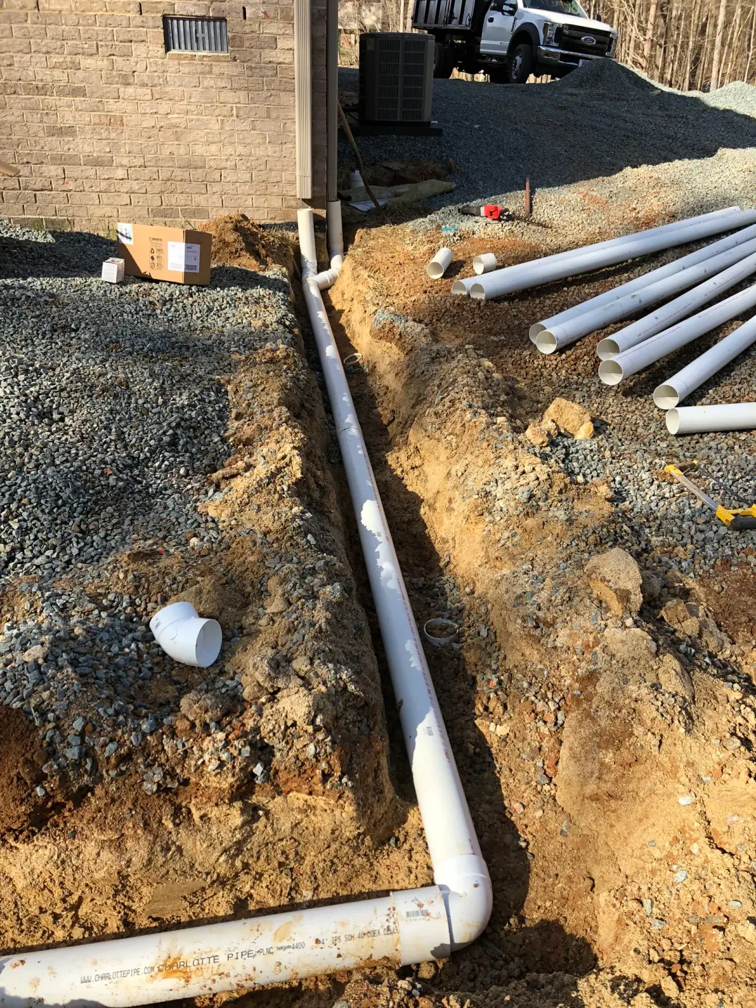 PVC storm drain piping being installed and trenched on a J. Coble drainage project